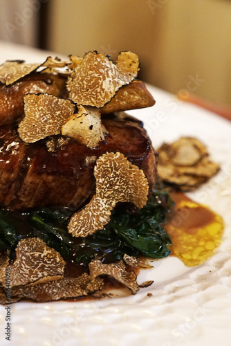 Close up Beef steak filet served with sauteed spinach, port sauce, Foie Gras and sliced black truffle