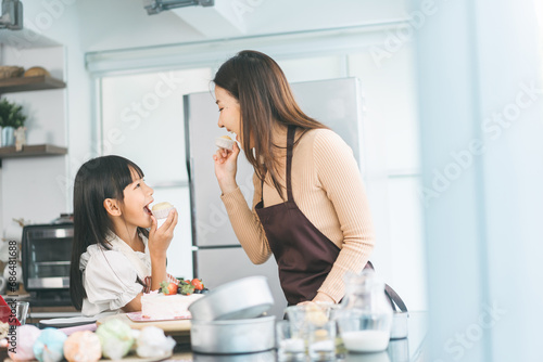 Mother and daughter cooking in kitchen preparation food for dinner meal, lifestyles together child with parent photo