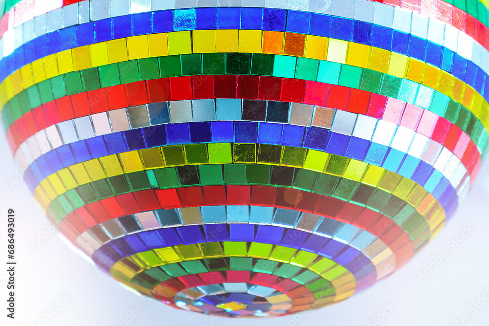 Fototapeta premium Disco ball with colored glass mirrors in selective focus.Close-up.Taken in backlit and sun glare.
