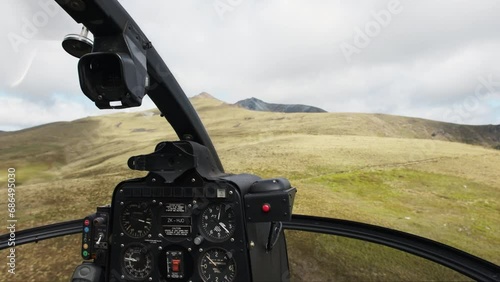 POV helicopter cockpit flying over majestic meadows on the side of the mountain photo
