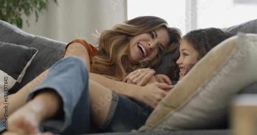 Mother, child and conversation on couch, happy and bonding at home, smile and communication. Mom, daughter and talking or hug, love and connection or trust, laughing and relaxing together in lounge photo