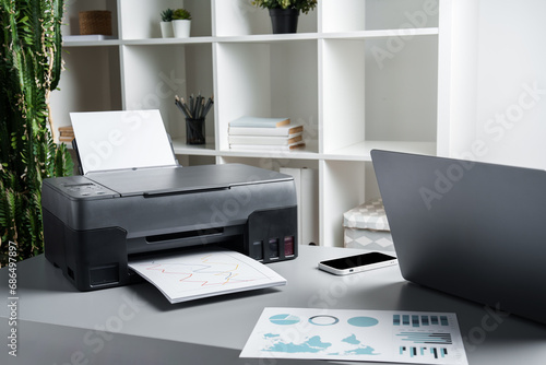 New modern printer and laptop in the office on table