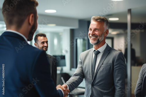 A new male employee gets a warm welcome from an office manager and other staff on the first day of a meeting, a welcome celebrating party for new staff at an office company. Generative AI.