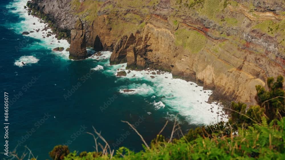 Slow motion wide shot of rocky coastline from high viewpoint. Colorful turquoise ocean waves crushing on the rocks. Picturesque view of the coastline. Slow motion wide shot of rocky coastline from high viewpoint. Colorful turquoise ocean waves crushing on the rocks. Picturesque view of the coastline.