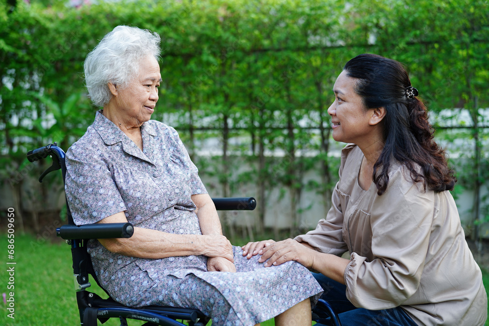 Fototapeta premium Doctor help Asian elderly woman disability patient sitting on wheelchair in park, medical concept.
