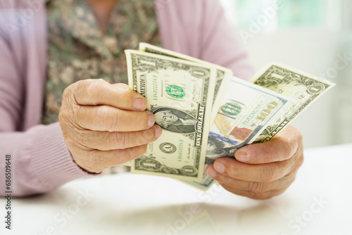 Retired elderly woman counting coins money and worry about monthly expenses and treatment fee payment.