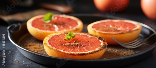 Broiled grapefruit with cinnamon and brown sugar, a nutritious treat for breakfast or snacking, served on a metal surface.