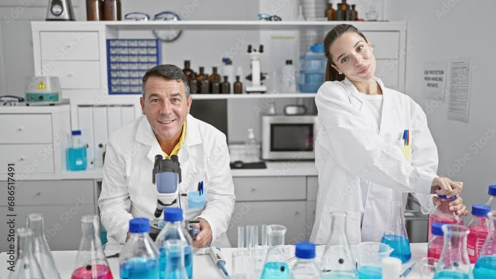 Man and woman scientists cheerfully working together in a high-tech laboratory Man and woman scientists cheerfully working together in a high-tech laboratory