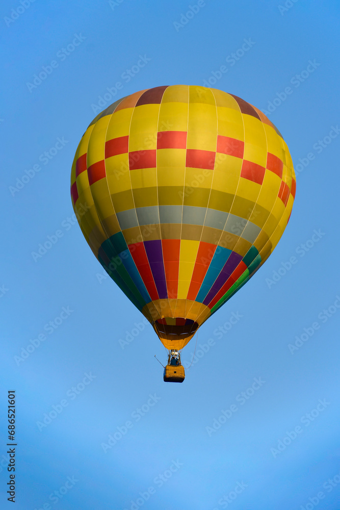 Naklejka premium Colorful balloon over blue sky in the bright sun light.