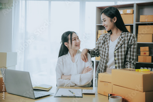 Two beautiful Asian women are happy and excited after receiving a new order from an SME customer. Commercial inspection. online marketing Boxes for entrepreneurs, SME sellers and independent online sa