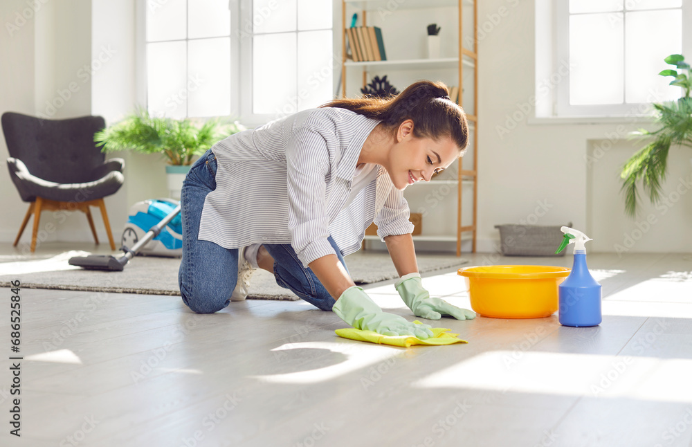 © Studio Romantic - Happy housewife cleaning the floor at home. Young woman in rubber gloves washing and wiping light gray wooden or laminate flooring in the living room. Housework concept © Studio Romantic - Happy housewife cleaning the floor at home. Young woman in rubber gloves washing and wiping light gray wooden or laminate flooring in the living room. Housework concept