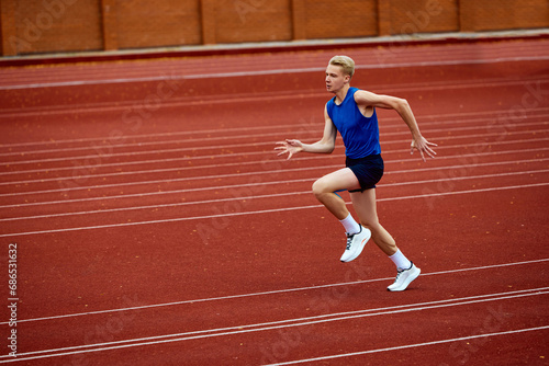 Burst of energy in running long jump. Young attractive sportsman running on sport court to make a perfect long jump to sand.