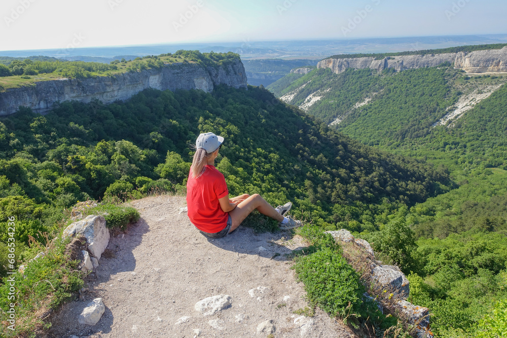 Mangup-Kale cave city, sunny day. A girl on the background of a mountain view from the ancient cave city of Mangup-Kale in the Republic of Crimea, Russia. Bakhchisarai.