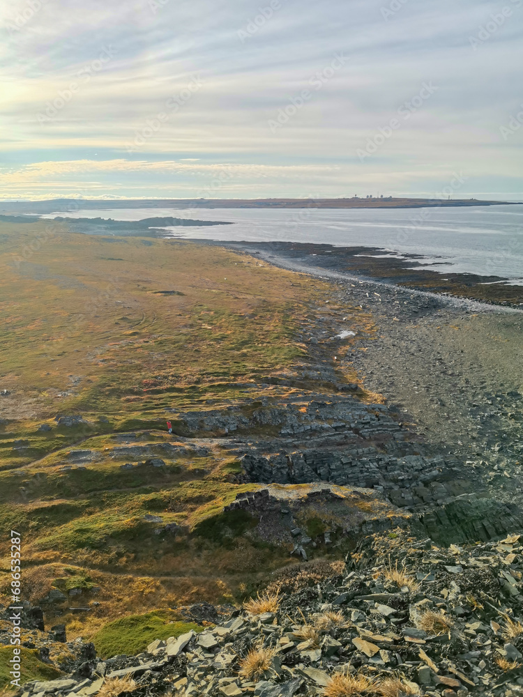 The rocky coast of the Barents Sea. Beautiful view of the rocks and the coast of the Rybachy and Sredny peninsulas, Murmansk region, Russia. The landscape is the harsh beauty of the north.