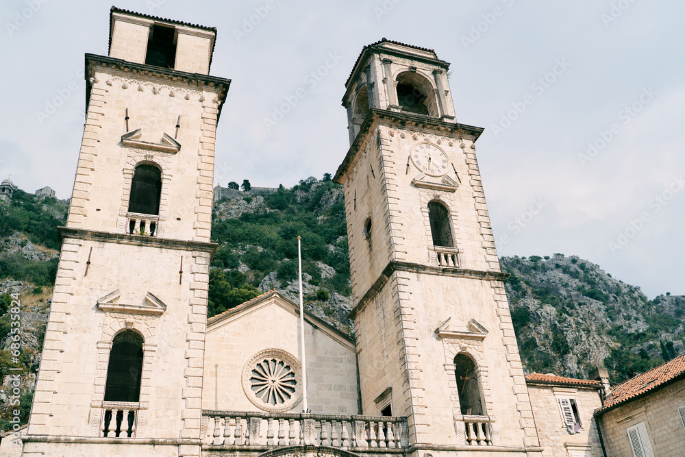 Bell towers of the Cathedral of St. Tryphon against the backdrop of green mountains. Kotor, Montenegro