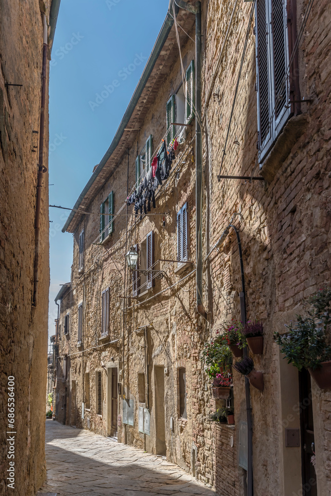 old stone houses in narrow street, Volterra, Italy