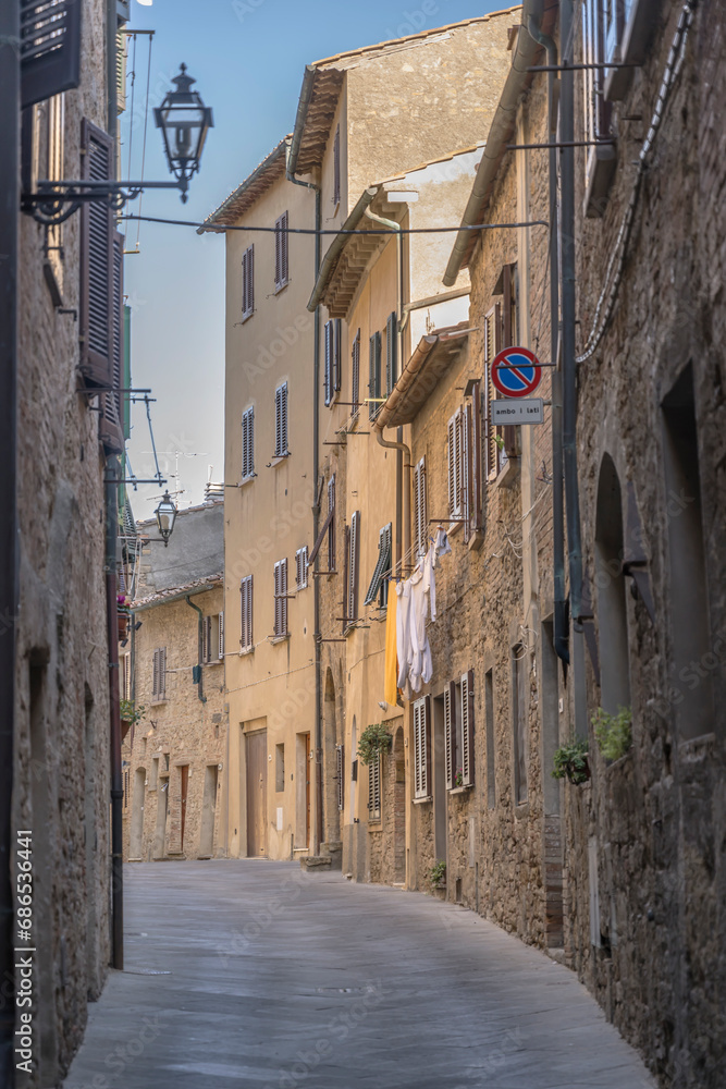 old houses in narrow bending street, Volterra, Italy
