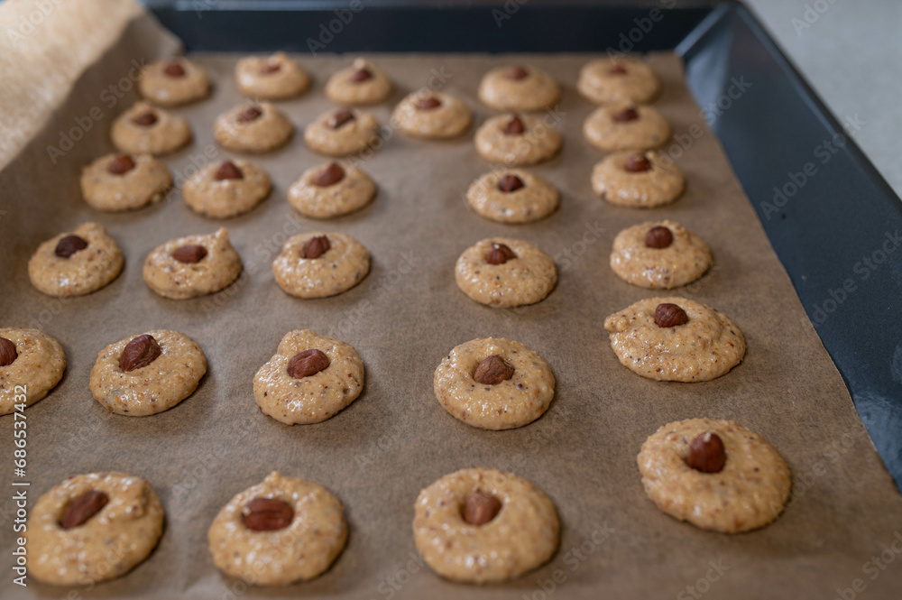 Raw and unbaked hazelnut christmas cookies on a baking sheet ready to bake