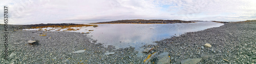 The rocky coast of the Barents Sea. Beautiful view of the rocks and the coast of the Rybachy and Sredny peninsulas, Murmansk region, Russia. The landscape is the harsh beauty of the north. photo