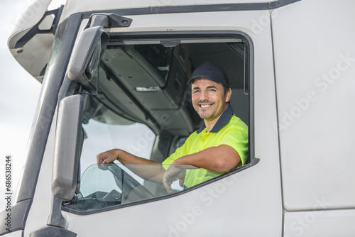 Smiling male driver looking through window of truck
