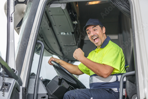 Cheerful male driver opening mouth in excitement while driving truck photo