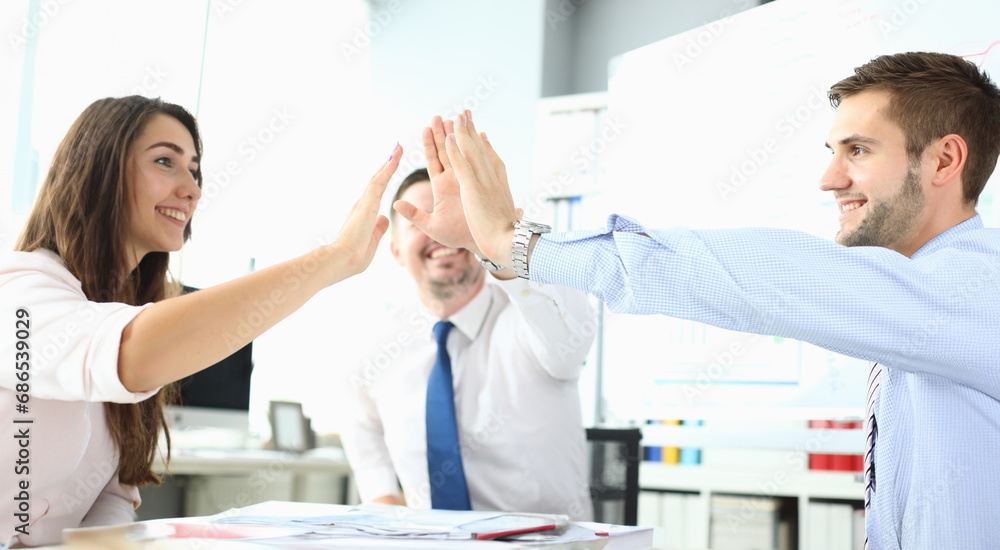 Obraz premium Happy business team high five in office. Business success and victory concept