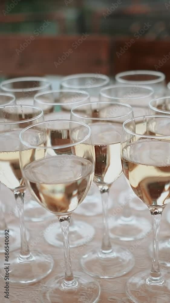 A glass of champagne stands on the festive table at the wedding of the bride and groom A glass of champagne stands on the festive table at the wedding of the bride and groom