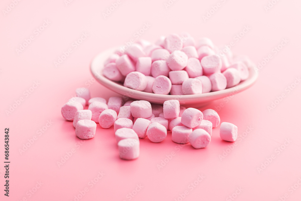 Mini sweet marshmallows candy on plate on pink background. Mini sweet marshmallows candy on plate on pink background.