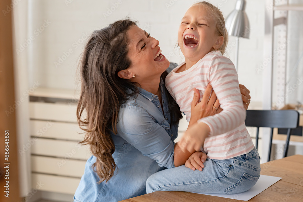 A child loves her mother. Cheerful smiling mother and daughter cuddling, hugging, and having fun at home. Mothers day A child loves her mother. Cheerful smiling mother and daughter cuddling, hugging, and having fun at home. Mothers day