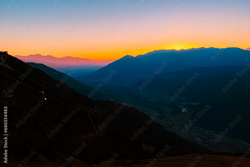 Alpine summer sunrise with Mount Patscherkofel in the distance at Mount Kreuzjoch, Fulpmes, Stubaital valley, Innsbruck, Austria