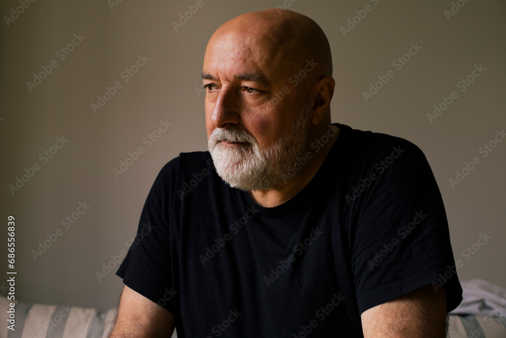 Depressed mature man with shaved head at home Depressed mature man with shaved head at home