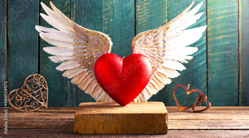 Valentine's day concept red heart with wings sitting on a wooden pedestal