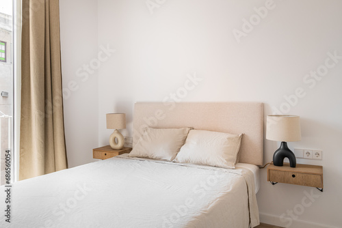 Double bed with pillows and blanket in minimalist bedroom