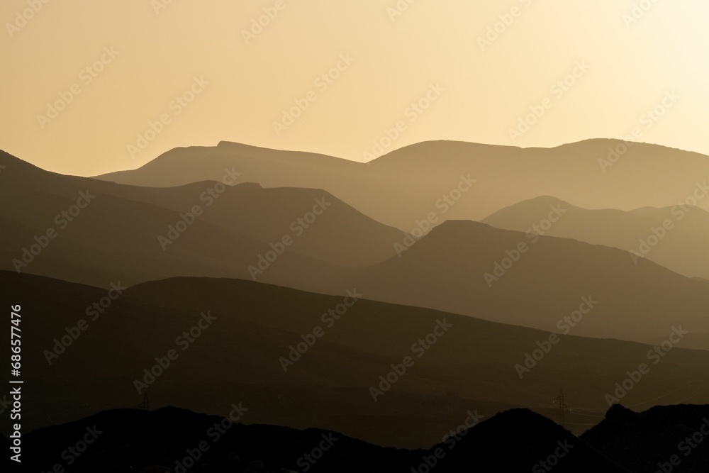Scenic view of majestic mountains illuminated by a golden sunset