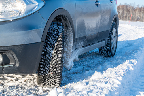 close up of studded tires on car standing on snow © Jonas