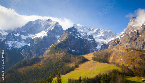 Alpine mountains in winter covered with snow, green meadows © Tatiana
