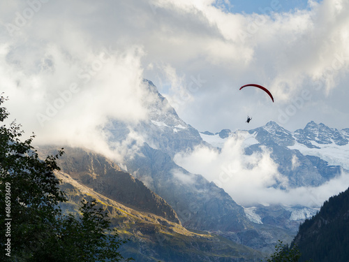 Paragliding with mountains and glaciers background in Swiss Alps