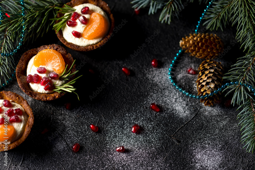 Christmas nut tartlets. Delicious, beautiful cupcakes are decorated with Christmas garlands and Christmas tree branches. Selective focus. Copy space Christmas nut tartlets. Delicious, beautiful cupcakes are decorated with Christmas garlands and Christmas tree branches. Selective focus. Copy space