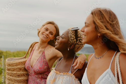 Multiracial group of female friends taking a joyful stroll and having a good time on the beach. Concept of diversity, femininity and empowerment.