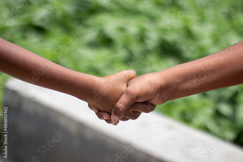 A man is shaking hands with another man and green background © Rokonuzzamnan