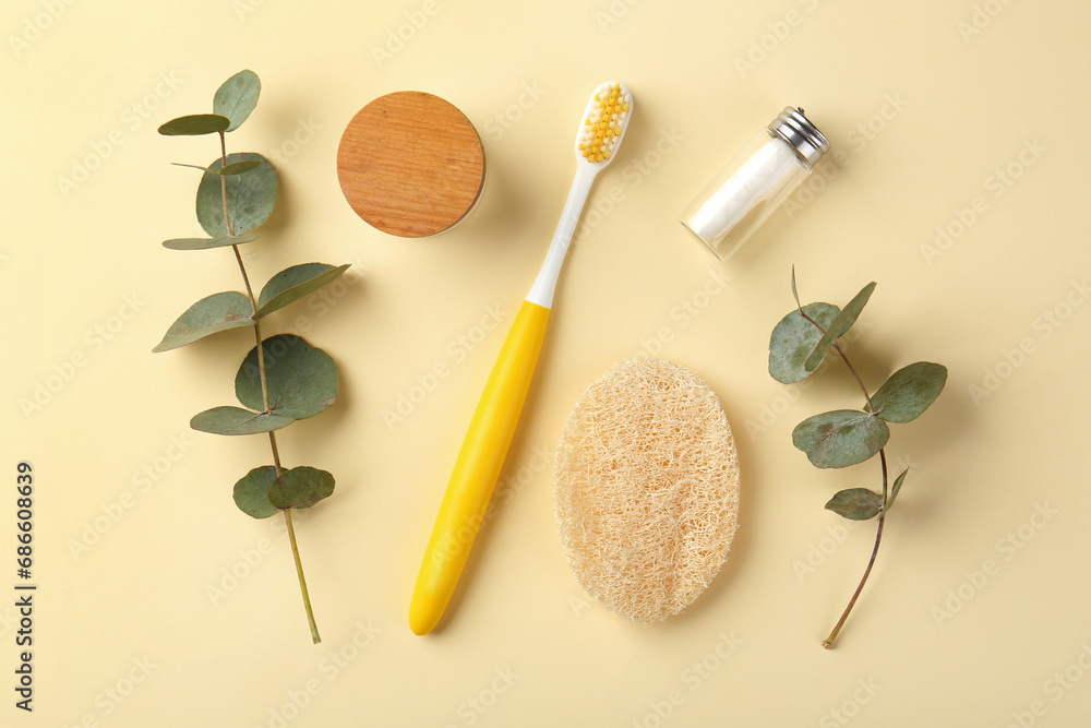 Plastic toothbrush, eucalyptus branches and other toiletries on pale yellow background, flat lay Plastic toothbrush, eucalyptus branches and other toiletries on pale yellow background, flat lay