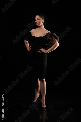 brunette woman posing in black studio