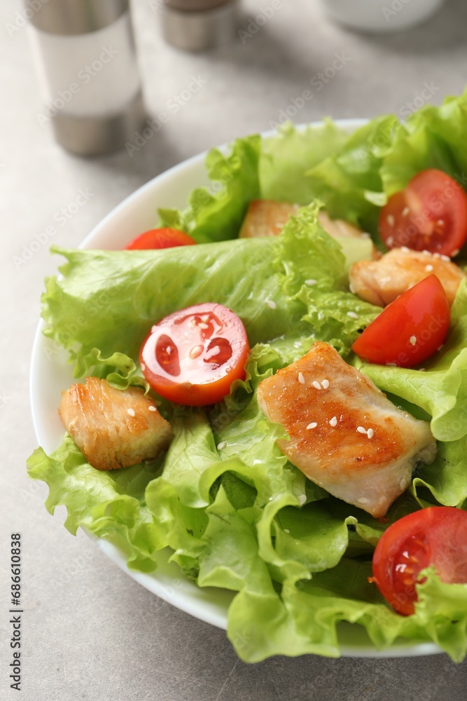 Delicious salad with chicken and cherry tomato on light grey table, closeup Delicious salad with chicken and cherry tomato on light grey table, closeup