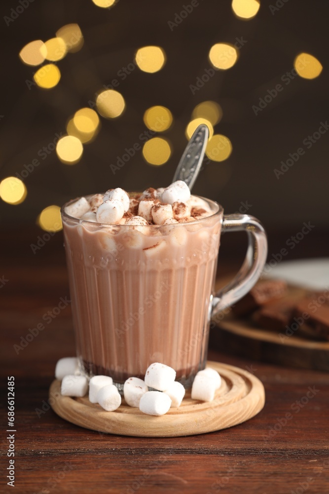 Cup of aromatic hot chocolate with marshmallows and cocoa powder on wooden table Cup of aromatic hot chocolate with marshmallows and cocoa powder on wooden table