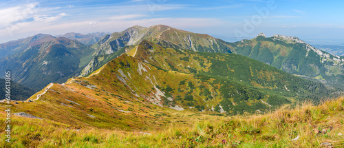 Polish Tatra Mountains, high mountain hiking trail leading to mountain peaks, mountain landscape with valleys and slopes, view on a sunny summer day. © Castigatio
