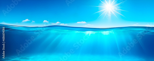 Beautiful Split underwater view of light blue ocean and sunny sky. Banner format.