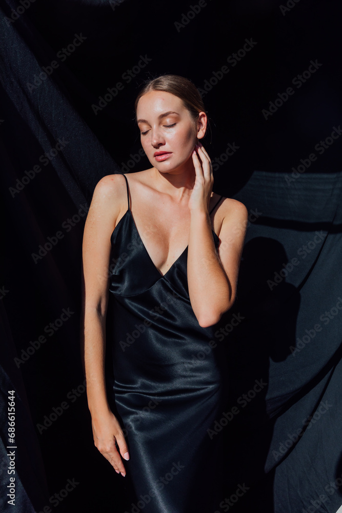 Beautiful fashionable slender woman in black silk evening dress Beautiful fashionable slender woman in black silk evening dress