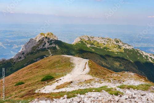 Polish Tatra Mountains, high mountain hiking trail leading to mountain peaks, mountain landscape with valleys and slopes, view on a sunny summer day.