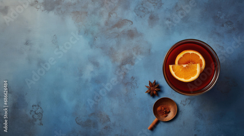 Hot mulled wine with spices on blue background. Top view, copy space.