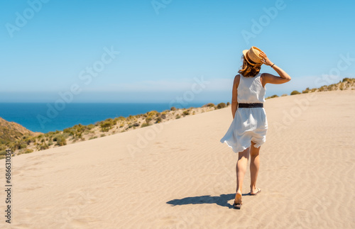 Woman strolling along a path with sea views